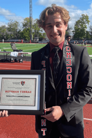 W&J Senior Garret Hampton poses on the track holding a plaque which recognizes him.
