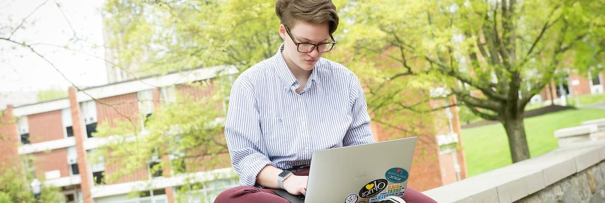 一名学生在笔记本电脑上工作，在罗辛校园中心庭院的墙上学习，在Creosote影响照片拍摄5月1日, 2019年华盛顿 & 澳门葡京博彩软件.